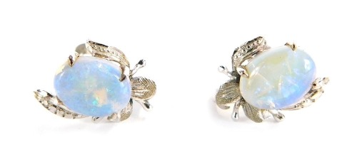 A pair of opal and diamond set spray earrings, each with leaf moulded detailing around an opal, on a white metal backing with screw in back, stamped 10K, 2.4g all in.