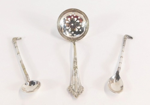 A group of silver and plated spoons, comprising two Victorian silver riding crop salt and mustard spoons, and a silver plated sifter spoon. (3)