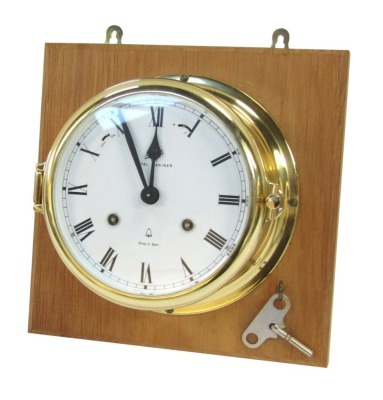 A Royal Mariner ship's wall clock, in brass case with white dial and Roman numerals, dated 1881, with clock key, 23cm x 23cm frame, dial 12cm diameter.