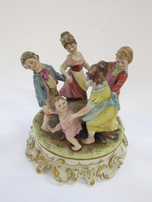 A Capo di Monte porcelain figure group, by Merli, modelled with a family dancing around a tree stump, on a rococo scroll base, 20cm high. - 2