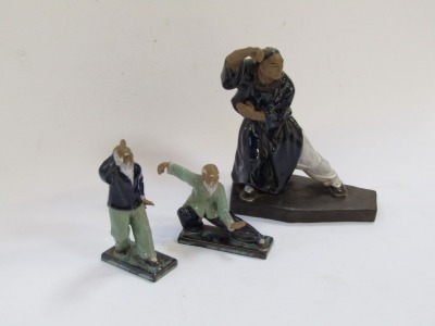 Three Mudmen figures of Oriental figures in pose, each with a blue and green glazed finish, the largest 23cm high. - 2