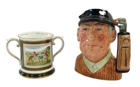 Two golfing related tankards, comprising a Royal Doulton Golfer character jug, D6623, and an Antique Golfing Scenes porcelain loving cup by Spode, golfing scene after an early 19thC sketch.