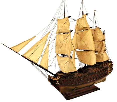 A model of a British Napoleonic era man-o-war, of fully rigged, triple masted form, raised on a cradle bracketed base, 86cm high, 105cm wide.