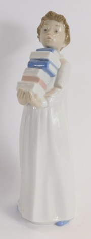 A Nao porcelain figure of a child carrying books, 28cm high.