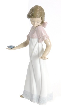 A Nao porcelain figure of a girl carrying a candle stick, 25cm high. (AF)