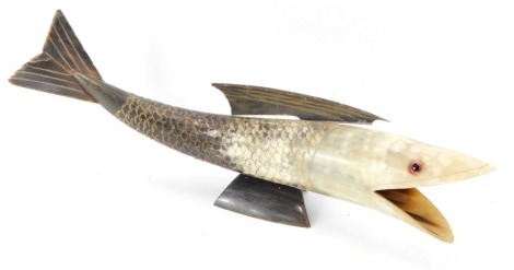 A carved horn fish ornament, with applied glass beaded eyes and detachable fin, 42cm wide.