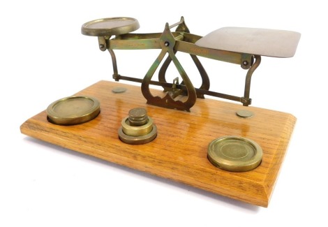 An early 20thC table top postal set, with brass scales and arrangement of five various weights, 22cm wide x 11cm deep.