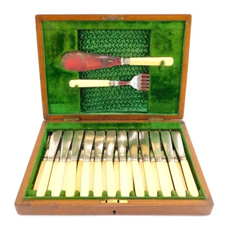 A silver plated and bone handled fish serving set, for twelve place settings, enclosed in an oak box with brass shield and green velvet lined interior, 6cm, high, 36cm wide, 25cm deep.