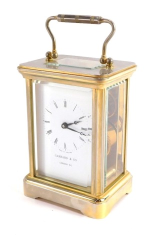 A Garrard and Co of London brass cased carriage clock, rectangular enamel dial bearing Roman numerals, single barrel movement, the case of conventional form, with key, 12cm high, 9cm wide, 7cm deep.