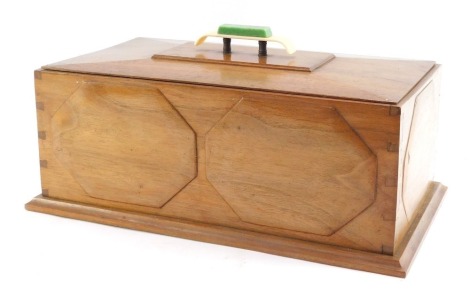 A 1950's Art Deco style mahogany casket, with Bakelite knop, and green baize interior, 14cm high, 36cm wide, 20cm deep.