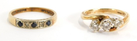 Two 9ct gold dress rings, comprising a 9ct gold half hoop eternity ring set with sapphires and diamonds, together with a diamond set three stone dress ring, yellow metal, unmarked, possibly 9ct, 4.6g all in.