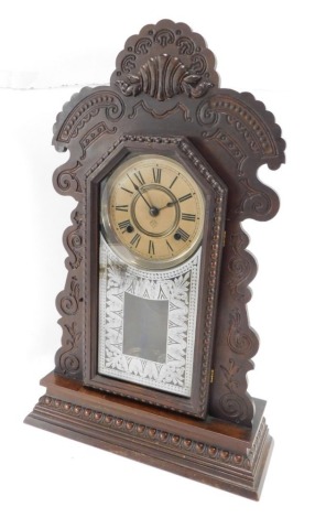 An early 20thC mahogany mantel clock, the arched top with shell and scroll finial, on a painted dial marked Ansonia clock company New York, 58cm high, 36cm wide, 12cm deep.