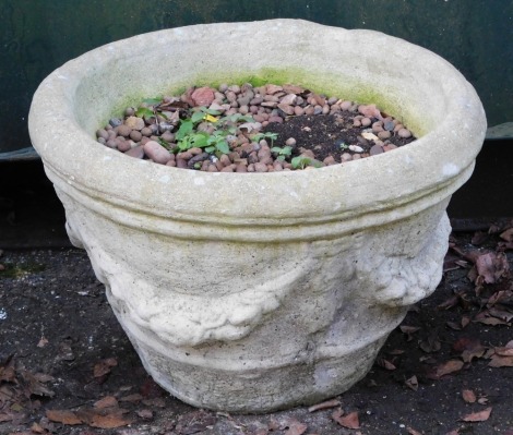 A cast concrete planter, circular with bow drop detailing, 32cm high, 55cm wide.