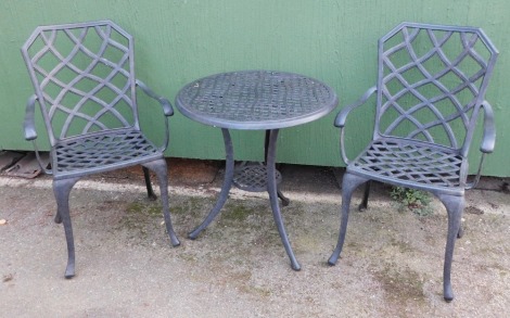 A metal finish garden table, circular on tripod base, with two matched chairs, each of hatched detailing, 71cm high, 64cm diameter.