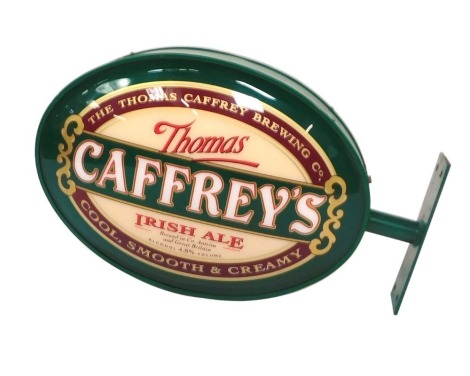 A Thomas Caffrey Irish ale oval advertising sign, with a metal exterior and perspex glass painted advertising panel, 76cm wide, 45cm high.