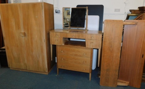 A Russell of Broadway walnut bedroom suite, 1950's, comprising two door wardrobe, dressing table set, double bed frame and chest of drawers, the wardrobe 180cm high, 121cm wide, 56cm deep, the dressing table 135cm high, 123cm wide, 47cm deep, chest of dra