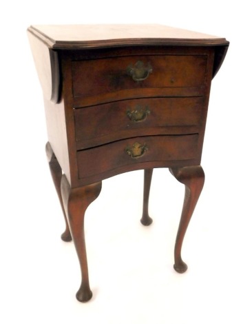 A walnut drop leaf side table, the kidney shaped top above three single drawers, on cabriole legs and pad feet, 71cm high, 39cm wide when closed, 36cm deep.