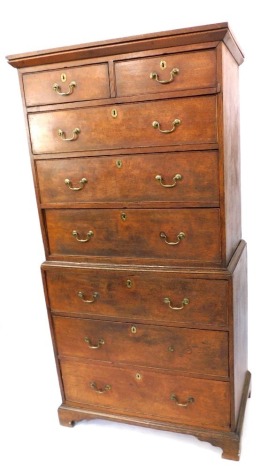 An early 19thC oak chest on chest, the top with a moulded cornice above two short and three long drawers, with a three long drawer base, brass drop handles, on bracket feet, 184cm high, 92cm wide, 53cm deep.