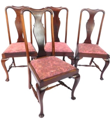 A set of four early 20thC mahogany dining chairs, each with a vase shaped splat and a moulded top, with drop in pink upholstered seats, on cabriole legs, 102cm high, 50cm wide, 42cm deep.