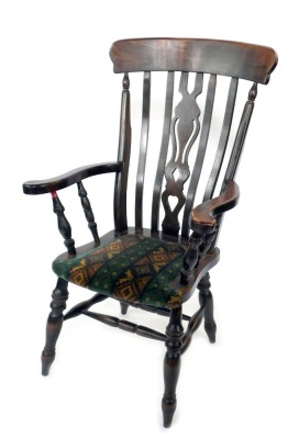 A stained beech grandfather chair, with central pierced splat back on curved arms with applied material seat, with turned legs, 110cm high, 63cm wide, 43cm deep.