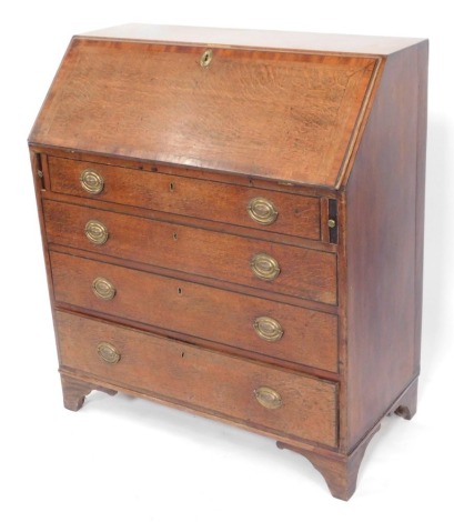 A George III oak and mahogany cross banded bureau, the fall opening to reveal a central drawer, flanked by six drawers and recesses, over four long graduated drawers, on bracket feet, with key, 104cm high, 91cm wide, 47cm deep.