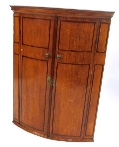 A 19thC oak bow fronted corner cabinet, each with mahogany banding and brass knop handle an escutcheon, 100cm high, 75cm wide, 47cm deep.