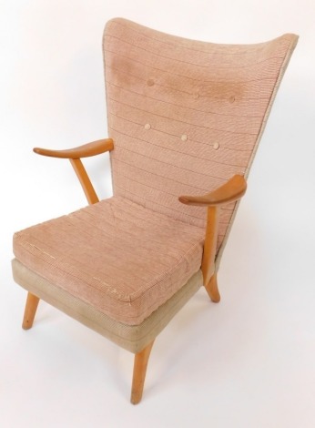 A Parker Knoll style vintage armchair, with beech supports and shaped shield backs, on button back upholstery, 98cm high, 72cm wide, 65cm deep. The upholstery in this lot does not comply with the 1988 (Fire & Fire Furnishing) Regulations, unless sold to a