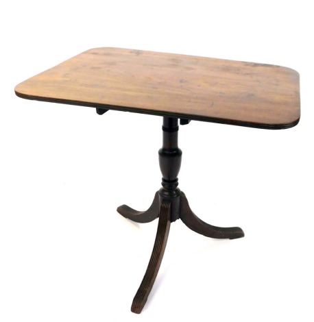 An early 19thC mahogany table, the rectangular top with rounded corners on a turned support with reeded out splayed tripod legs, 70cm high, 75cm wide, 54cm deep.