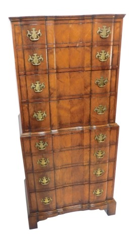 A Continental walnut block front chest on chest, the top with arrangement of four drawers, the base with four drawers, brass shield back plates, on bracket feet, 138cm high, 62cm wide, 46cm deep.