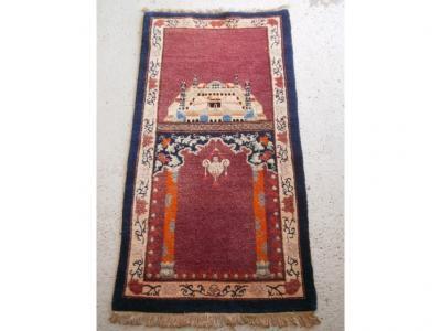 A small Persian rug, the central panel with a mihrab, and a picture of