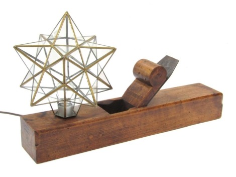 A wooden moulding plane table lamp, with a star shaped glass shade, 58cm long, 10cm wide.