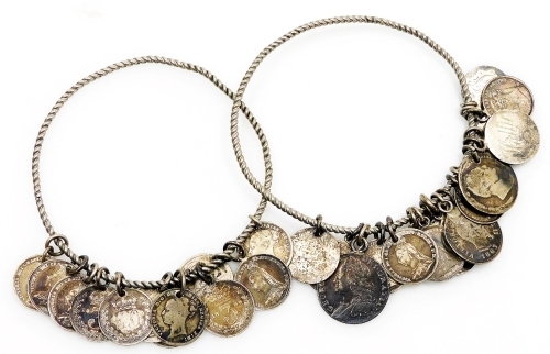 Two Victorian love token bangles, the first bearing eighteen engraved coins to include George, Middles & Mason, Hollie, T.S., Bob, the second with twelve engraved coins to include, T.W. Hodgkinson, Will, Millicent, J.B.