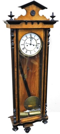 A late 19thC Vienna wall clock, in a walnut and ebonised case, the circular dial with enamel chapter ring bearing Roman numerals and subsidiary seconds dial, eight day movement, the case of architectural glazed form, 120cm high.