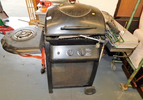 A Laguna two burner gas barbecue with side burner, and various implements.