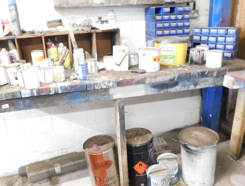 Wooden work bench and contents, including paints, thinners, spray guns, green plastic storage bin, etc.