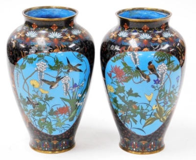 A pair of Japanese Meiji period cloisonne vases, of ovoid form, decorated with reserves of cranes, bamboo, and convolvulus, verso sparrows, wisteria and chrysanthemums, etc., against a background decorated with lion dogs, flowers, and foliate motifs, 31.5 - 3