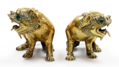 A pair of Chinese brass figures of dogs of fo, each inset with green paste stone eyes, 10cm high. - 2