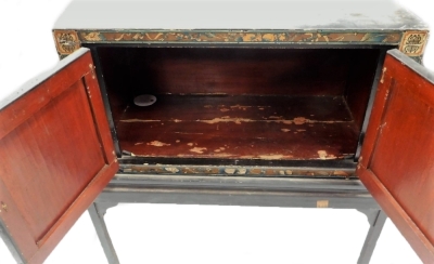 An antique Chinese lacquered chest on stand, decorated with figures on horse back, buildings, etc., on a black ground, with two doors enclosing a red painted vacant interior on a later ebonised base, 94cm high, the cabinet 85cm wide. - 2