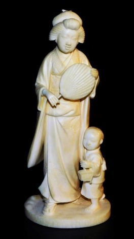 An early 20thC Japanese ivory okimono figure, of a geisha holding fan accompanied by a child, signed Kosshi to base, 16.5cm high.