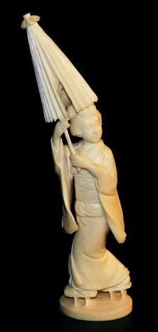 An early 20thC Japanese ivory okimono, of a geisha holding parasol, signed to base, 21cm high.