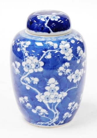 A Chinese blue and white porcelain ginger jar and cover, decorated with prunus blossom on a cracked ice ground, four character Kangxi mark to base, 21.5cm high.