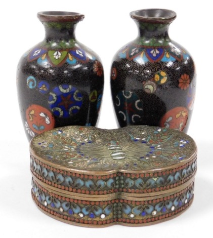 A Chinese brass and champleve enamelled box, of butterfly form, the wings decorated with flowers, 9cm wide, together with a pair of Japanese Meiji period cloisonne enamel vases, decorated with roundels of flowers and other symbols, against a black ground,