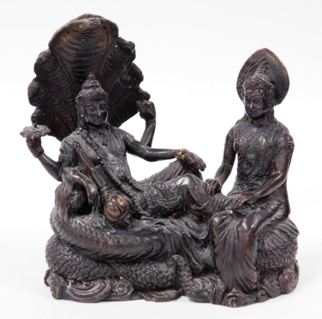 A Thai bronze figure group, showing the Buddhist god Phra Avalokitesuan, seated on cobra throne, with a sceptre and lotus flower, with a seated figure in attendance, 18cm wide.