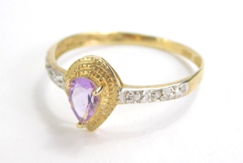 A ladies dress ring, claw set with a central amethyst coloured stone, flanked by small diamonds to each shoulder, marked 375, size O, 1.2g all in.