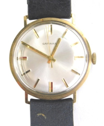 A gentleman's Garrard wristwatch, the 3cm dia. dial with baton numerals and pointers, with a black leather strap.