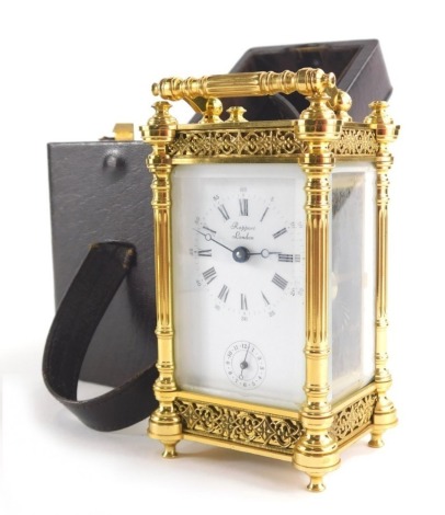 Rapport London. A gilt brass carriage clock with 5cm wide plate with Roman numeric and Arabic dial and subsidiary Arabic second hand, with turned columns and blind fret decoration in a five part glass case with key wind barrel movement, in fitted leather 