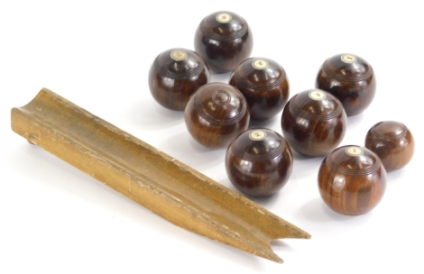 Various late 19thC lignum vitae carpet bowls, each numbered, 5cm dia. with wooden bowling ramp.