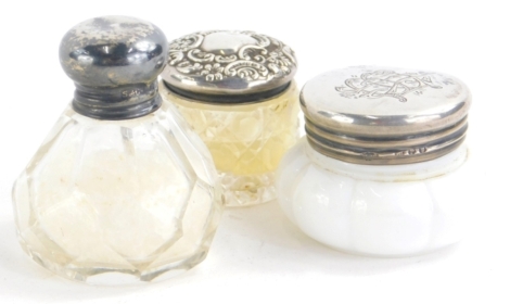 Three miniature dressing table jars, one 3cm high, with cut glass body and repousse decorated silver lid, etc. (3)