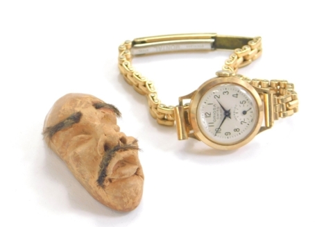 A 9ct gold ladies Oriosa Swiss wristwatch, with 2cm dial marked 9ct and a plated strap, 22g all in and an unusual clay head of miniature form. (2)