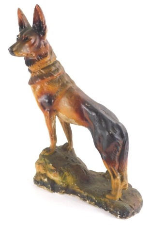 A 20thC plaster figure of an Alsatian, on a rock work base, 52cm high.